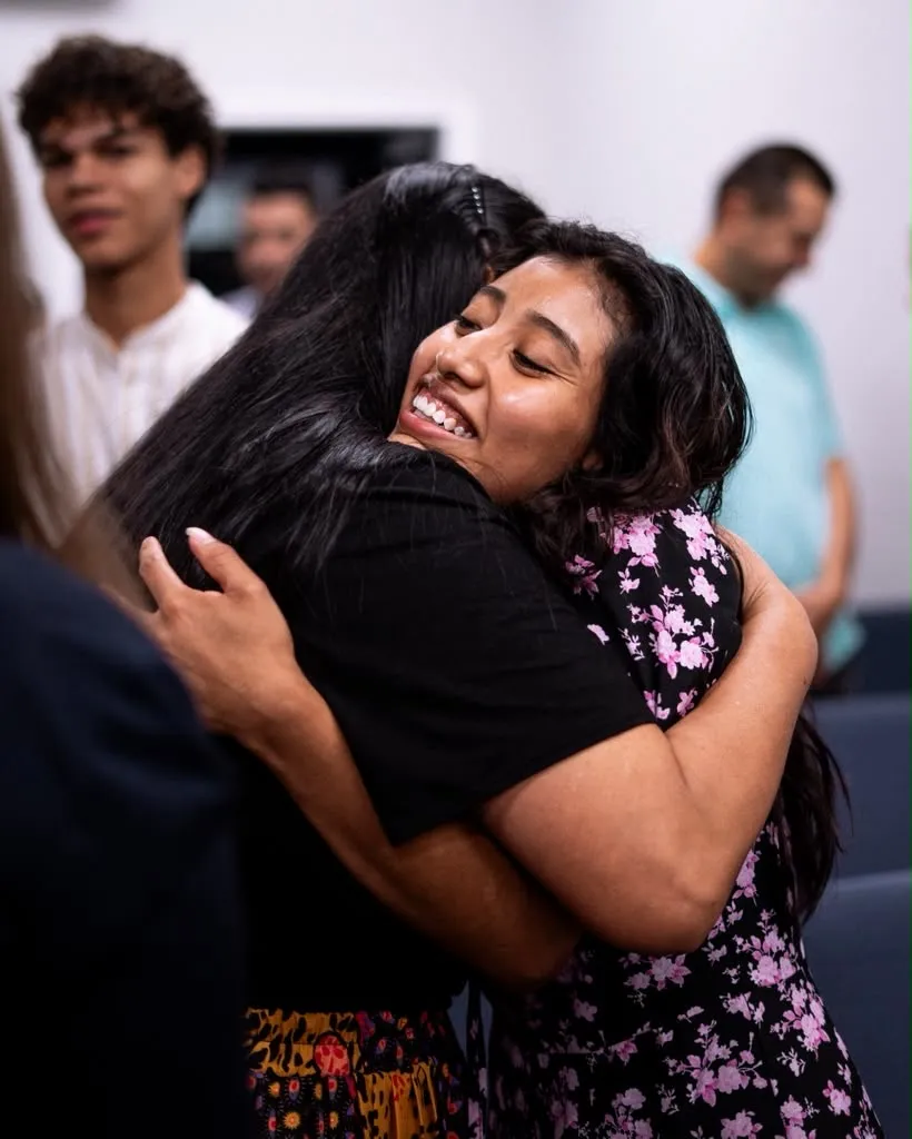 Dos mujeres se dan un abrazo durante el servicio