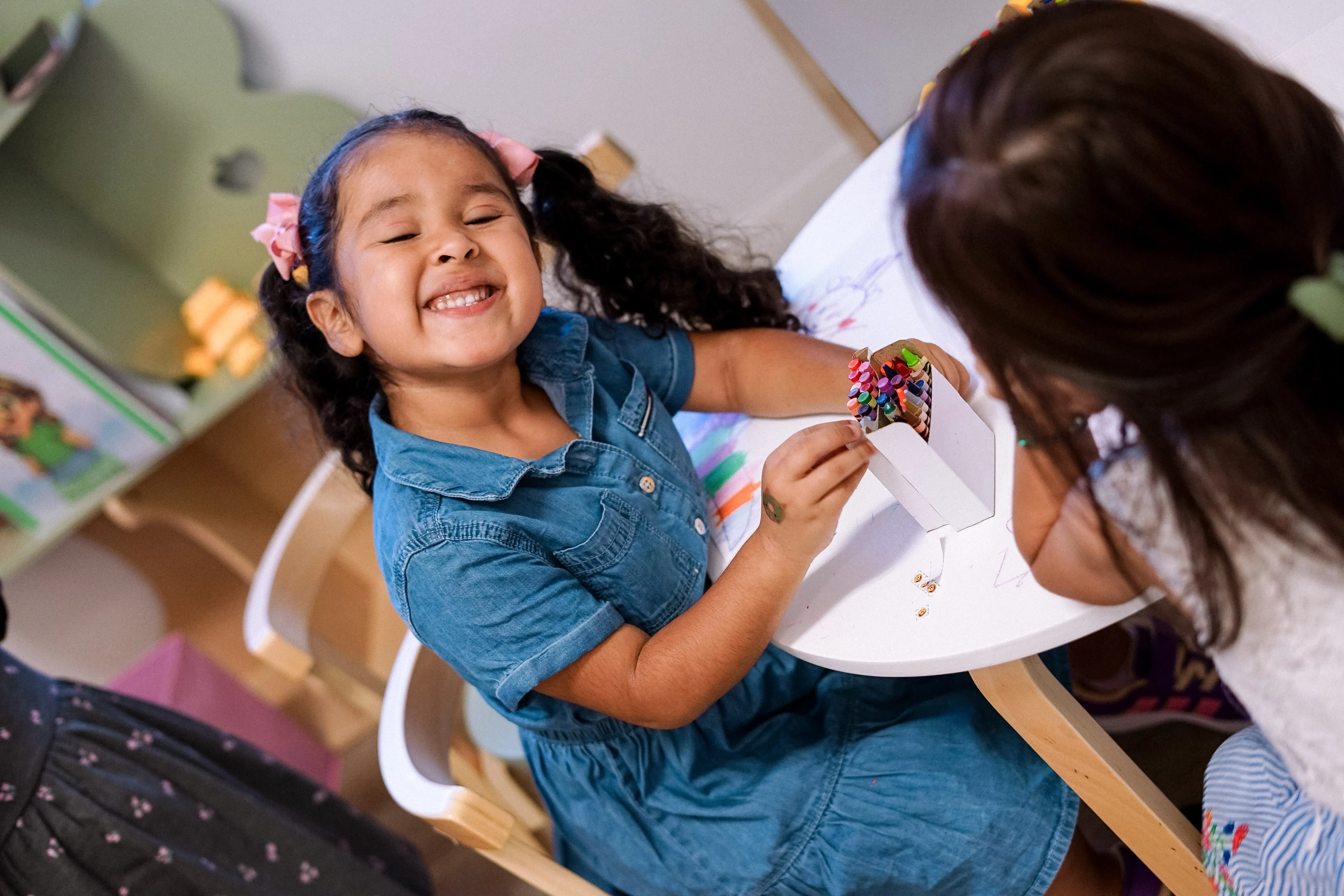 Una niña sonríe feliz mientras hace una manualidad en la clase de niños