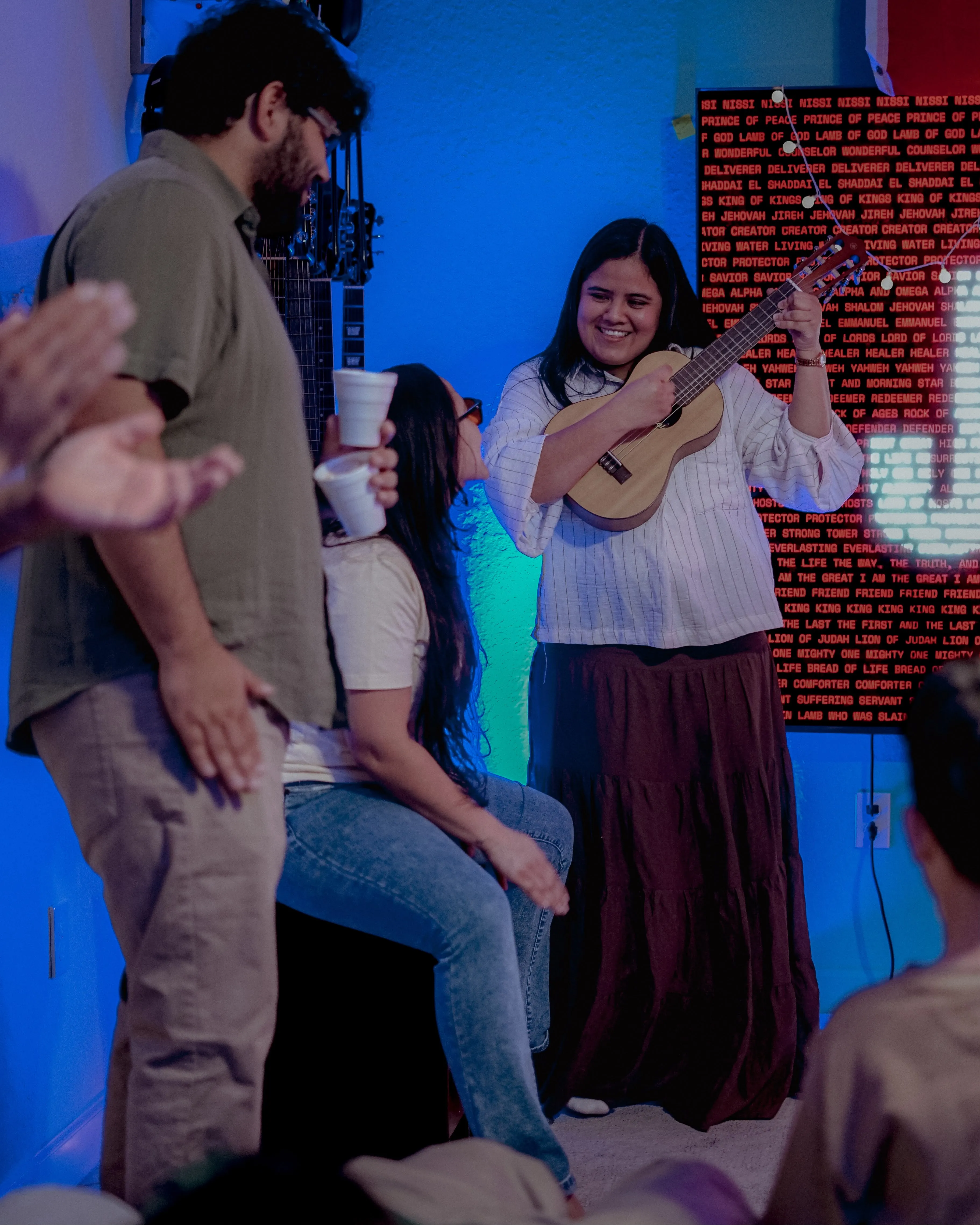 Jóvenes de Adorar Church compartiendo en una noche de jóvenes, con una joven tocando el ukelele